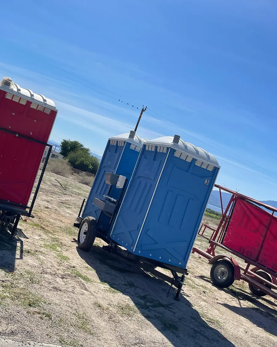 Porta potty at the edge of a rural field