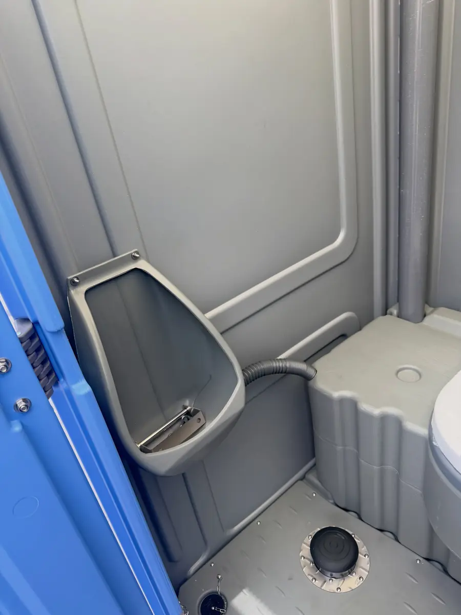 Interior of a standard porta potty showing the urinal and seat
